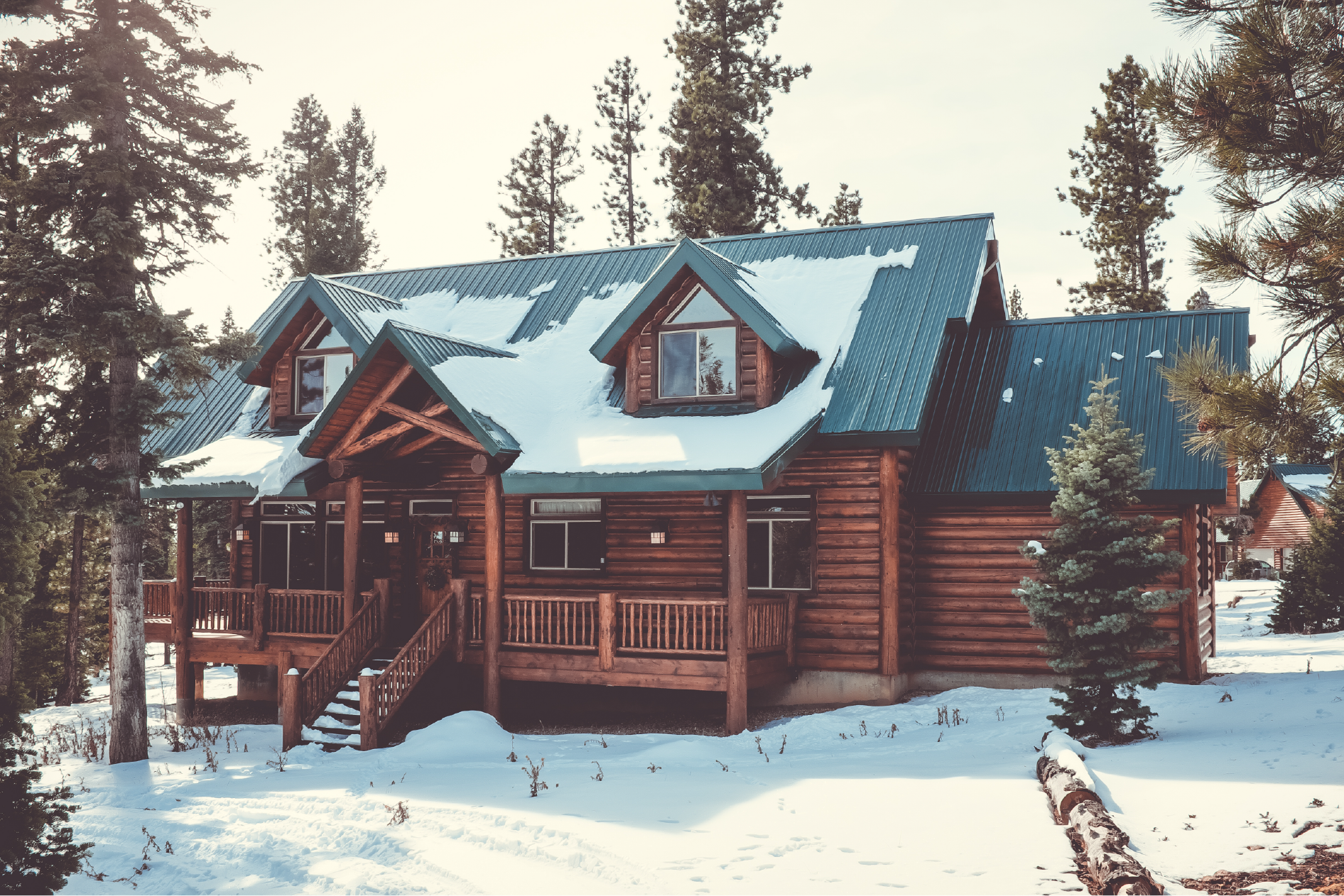 Log Cabin Home in Snow with Large Pines